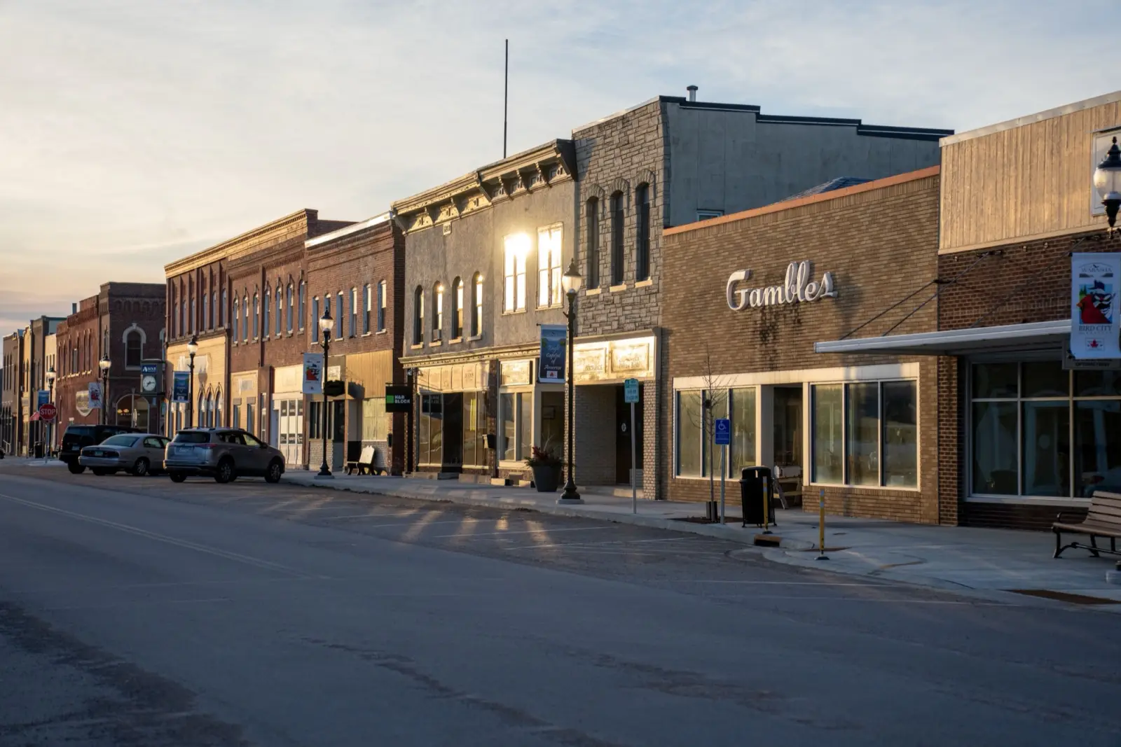 A small-town main street of storefronts at golden hour